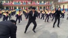 School pupils do choreographed shuffle dance with principal during break